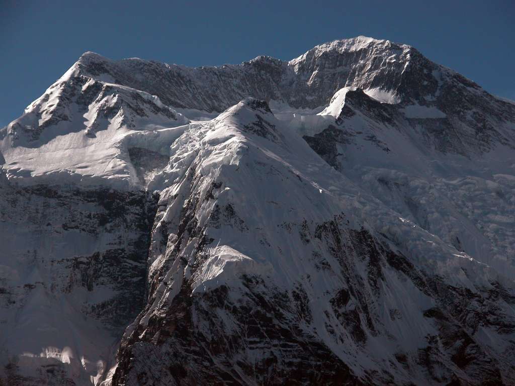 Annapurna 12 05 Annapurna II Full Summit Ridge From Ghyaru I decided to take the high route to Manang because it is supposed to be more interesting. From Pisang (3240m) I crossed the river and started the 450m ascent. On the climb from Pisang to Ghyaru, I had this great view of the full summit ridge of Annapurna II (7937m) to the southwest. Annapurna II was first climbed on May 17, 1960 via the West Ridge approached from the north by Chris Bonington, Richard Grant, and Sherpa Ang Nyima on a British/Indian/Nepalese team led by Jimmy Roberts.